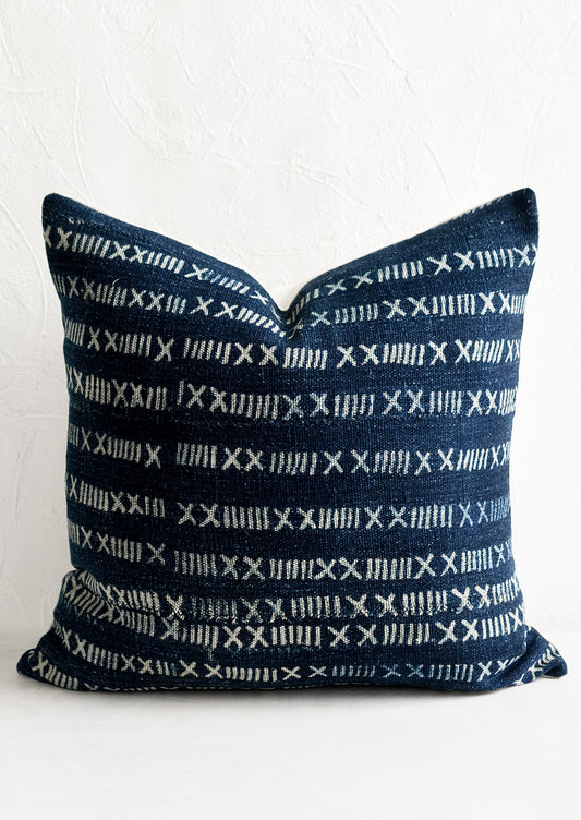 A throw pillow in indigo fabric with numeral pattern.