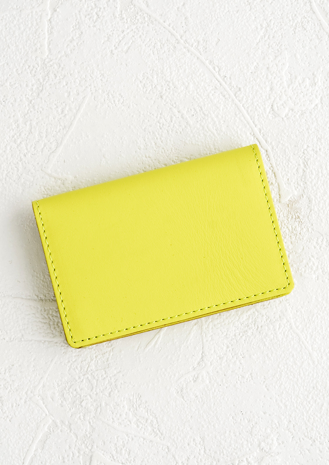 A small leather cardholder wallet in neon yellow.