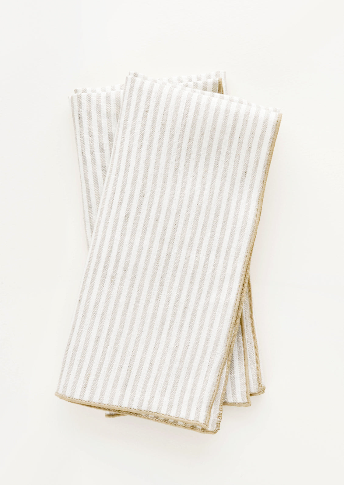 Pair of ivory folded Linen Napkins with light brown vertical stripe.