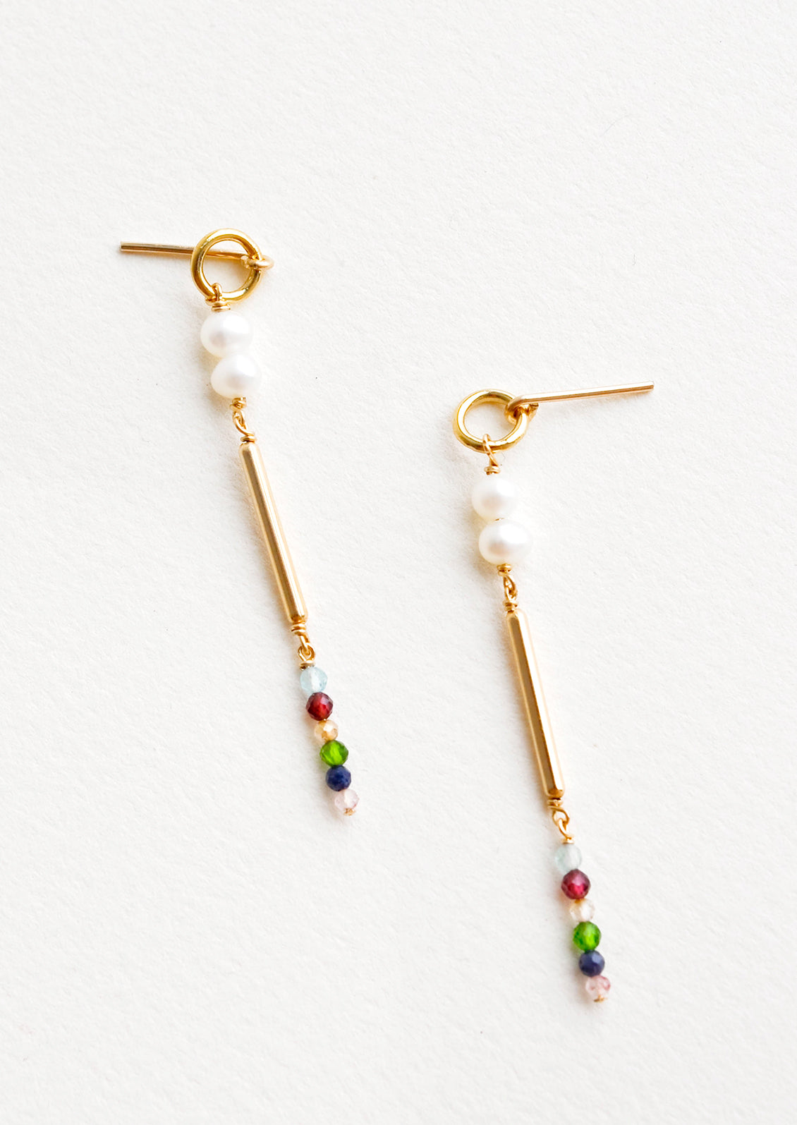 Dangling earrings featuring a small circle, two pearl beads, a gold post and six small multicolor gemstones on a yellow gold post back.