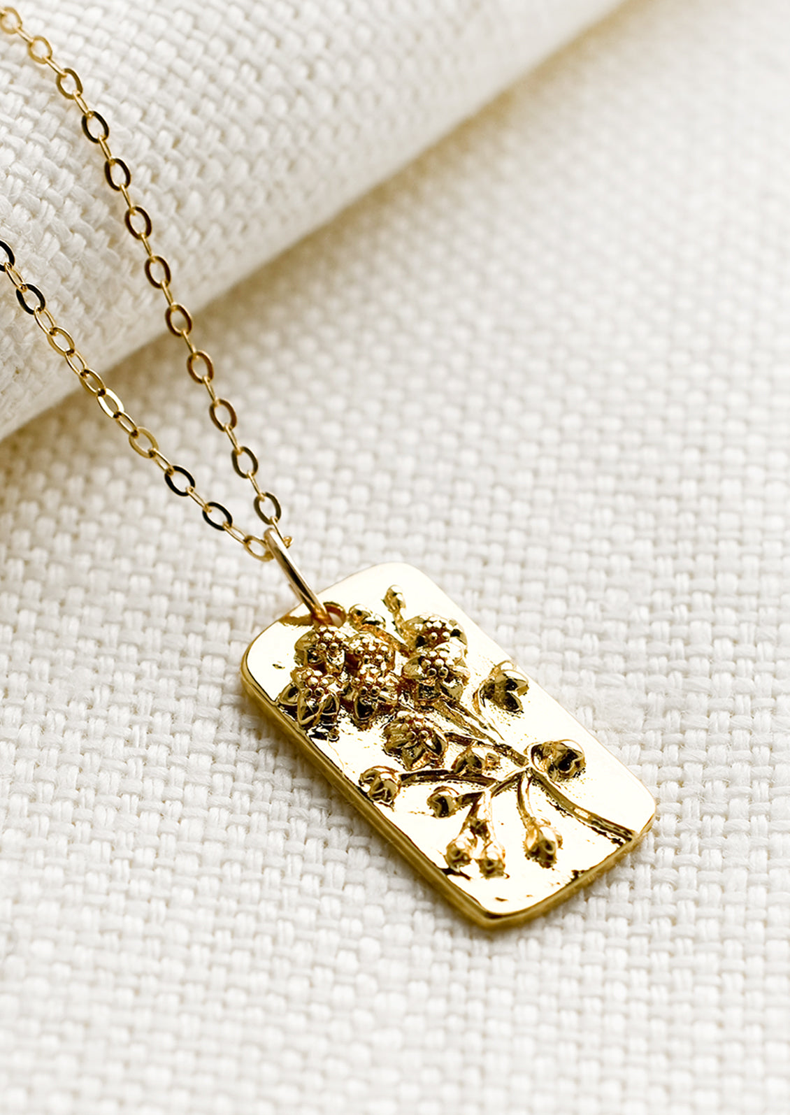 A tag style necklace with wildflower design.