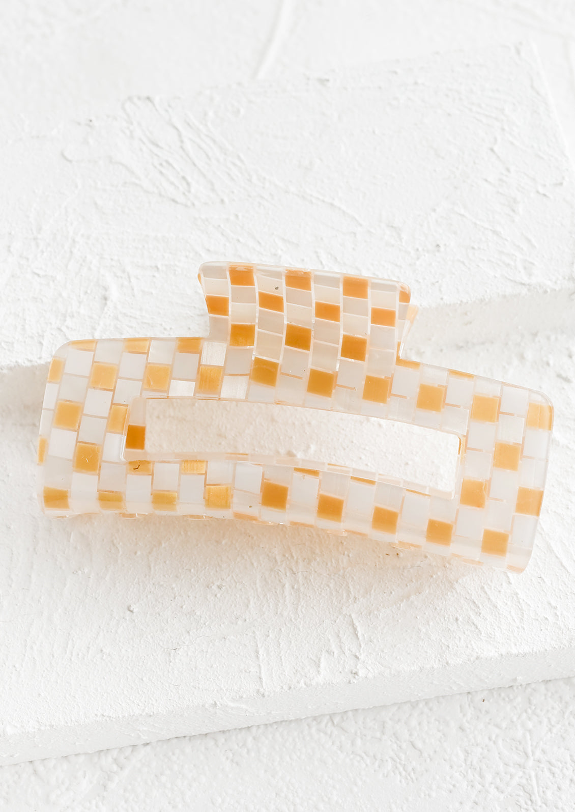 A rectangular acrylic hair clip in gold check.