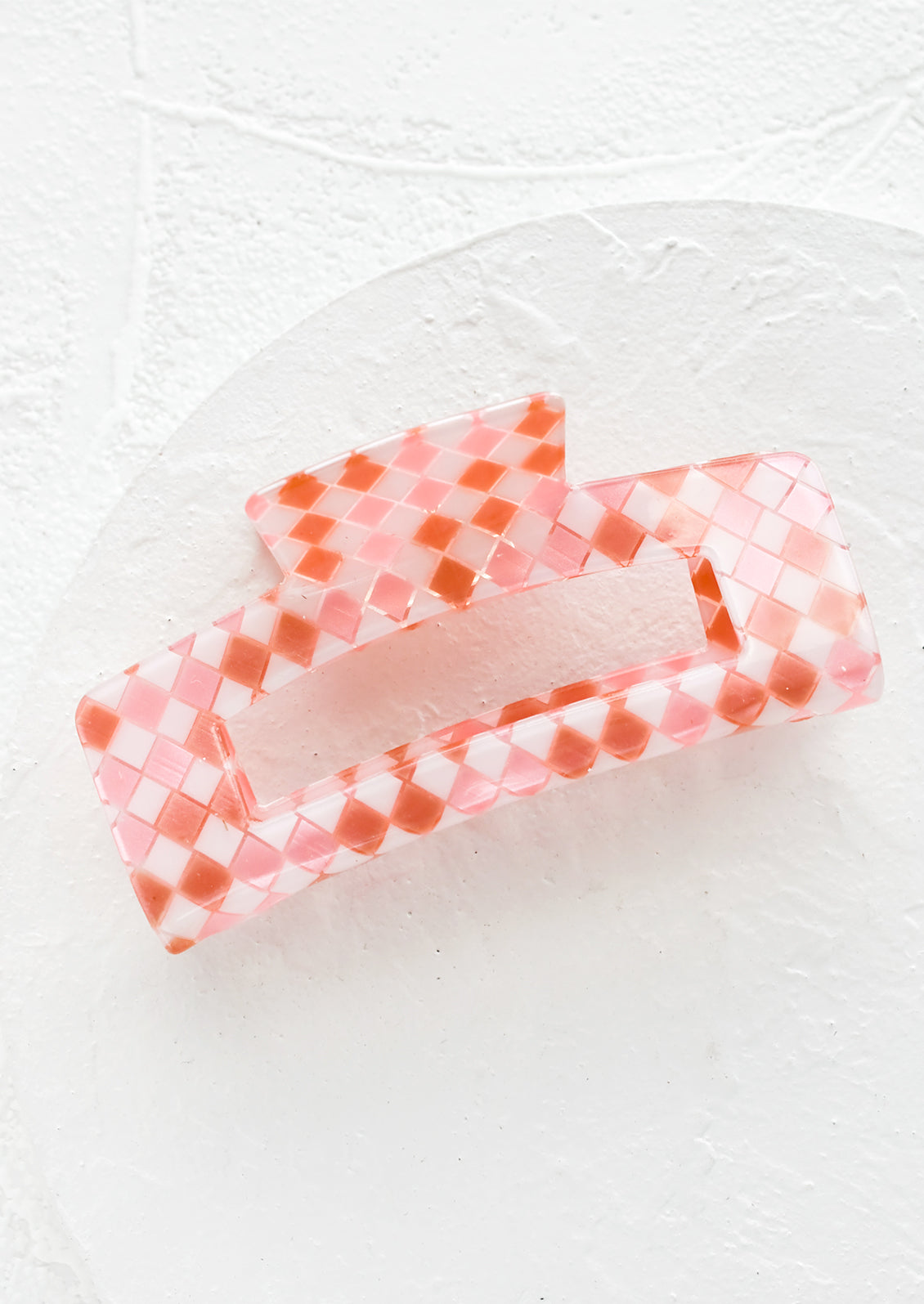 A rectangular acrylic hair clip in pink check.