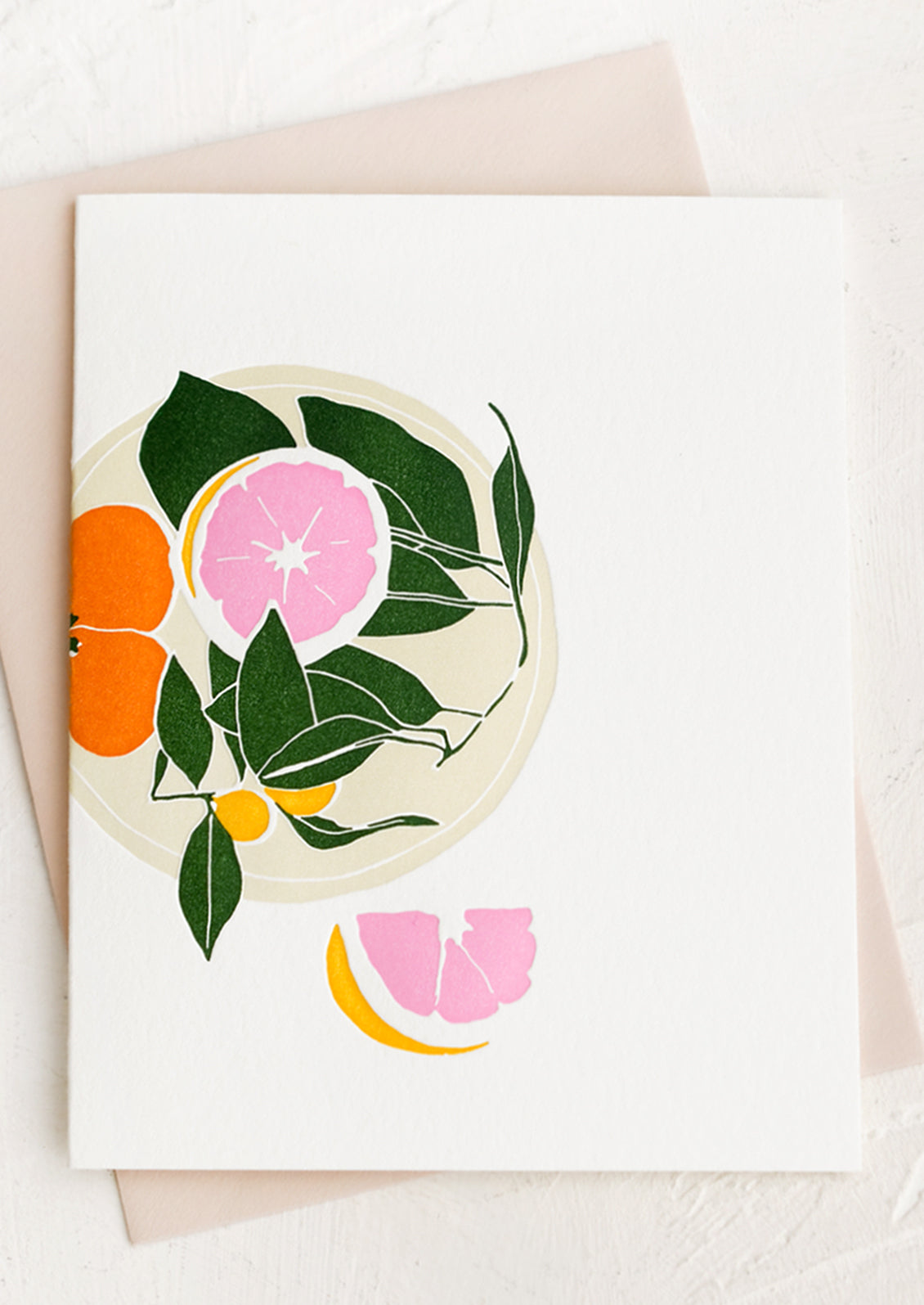 A letterpressed greeting card with assorted citrus fruits on a plate.