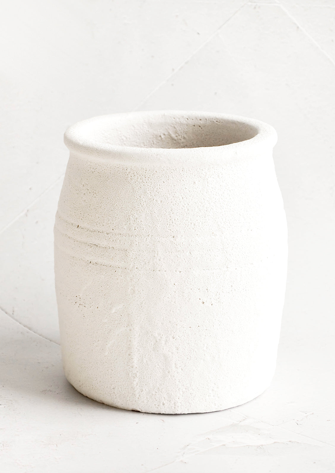 Crock-style utensil holder in ceramic with heavily textured, bubbly white glaze