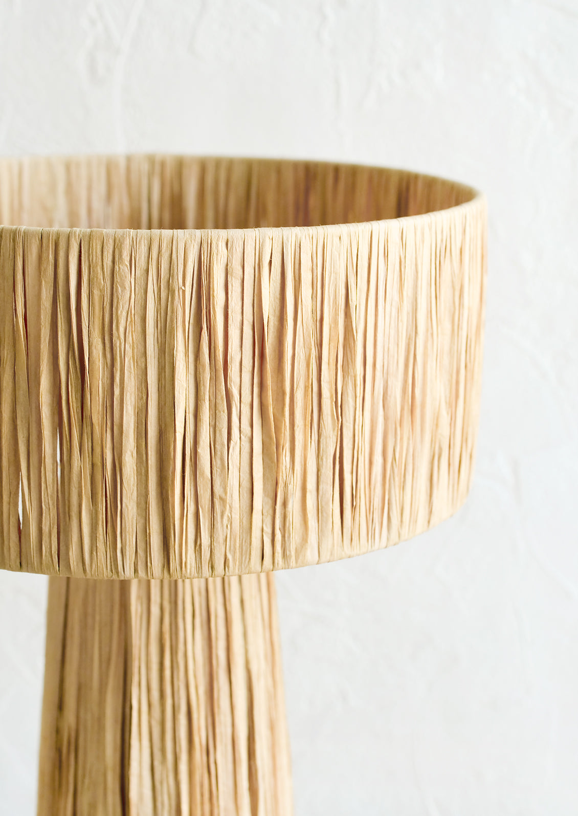 A table lamp wrapped in natural raffia.