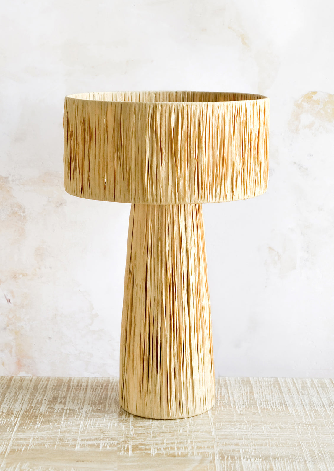 A table lamp wrapped in natural raffia.