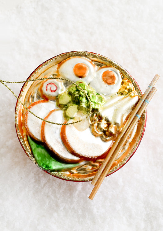 A decorative glass ornament in the shape of ramen noodle bowl.