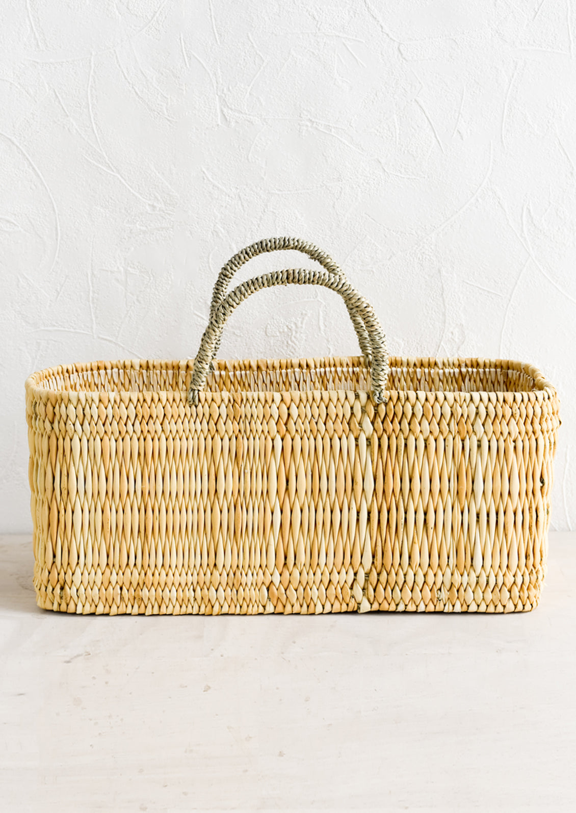 A rectangular storage basket made from natural reeds.