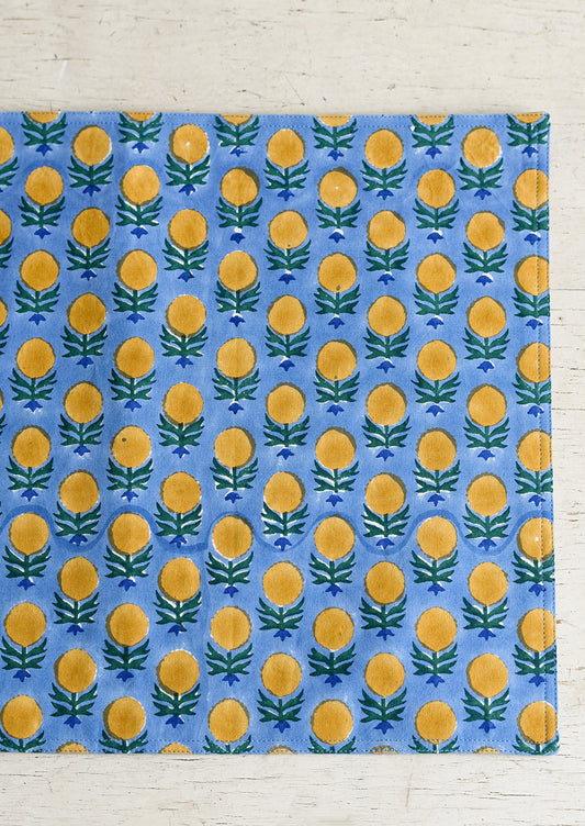 A blue and yellow floral block print placemat.