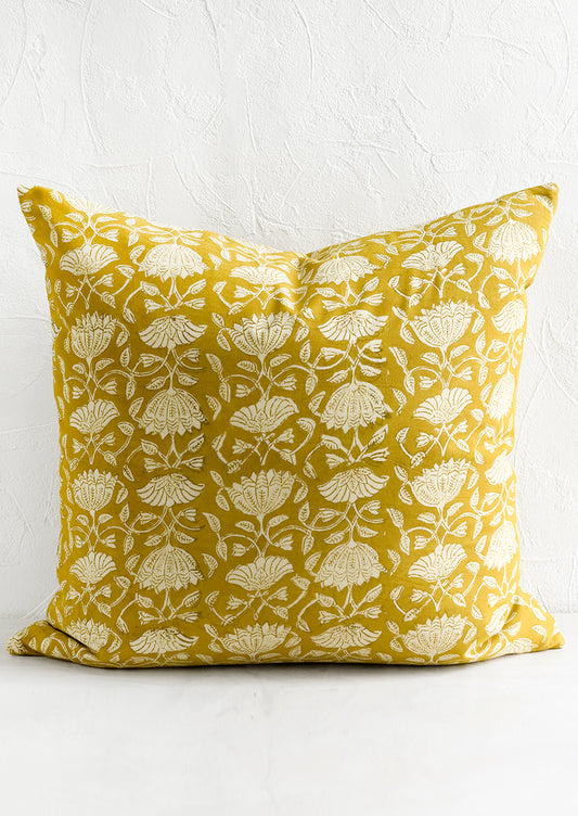 A pillow in yellow block print fabric.