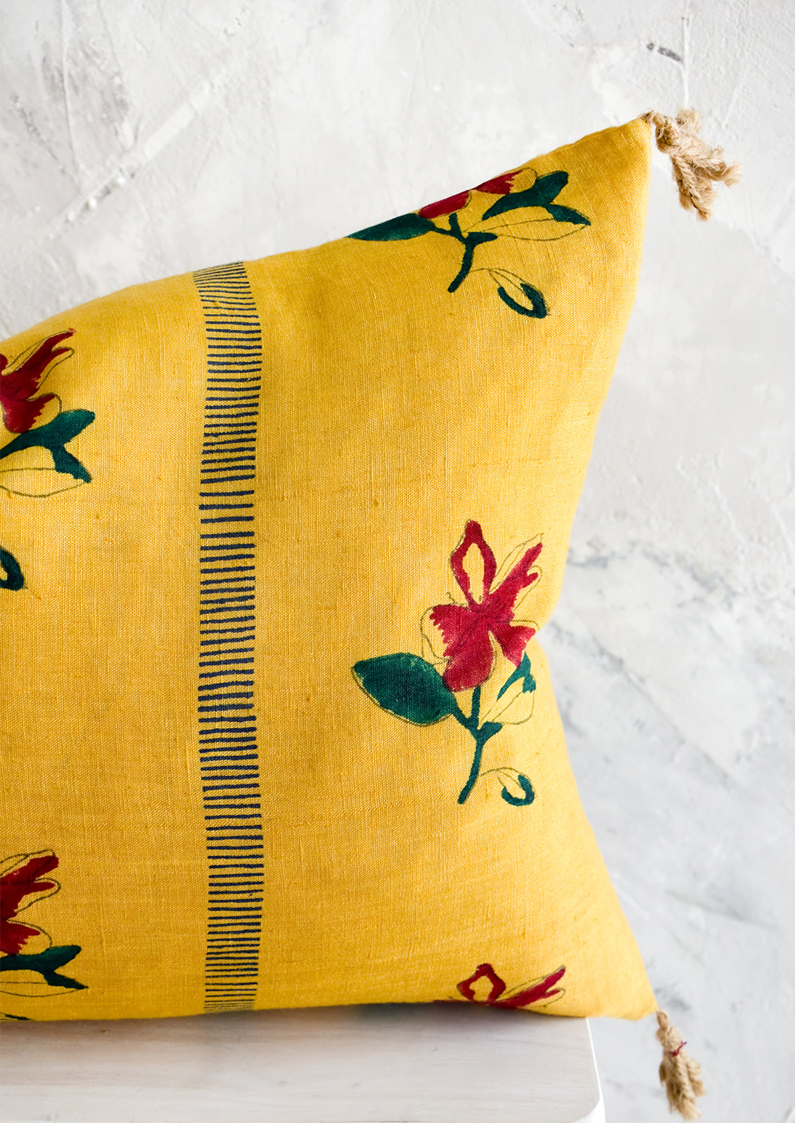 Linen pillow in mustard yellow with red and green block printed floral pattern