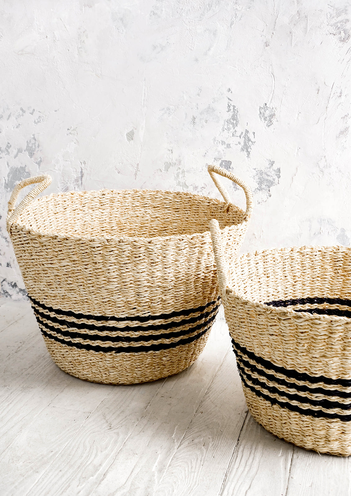 Round woven storage baskets with tapered bottom. Four black stripes printed at middle.