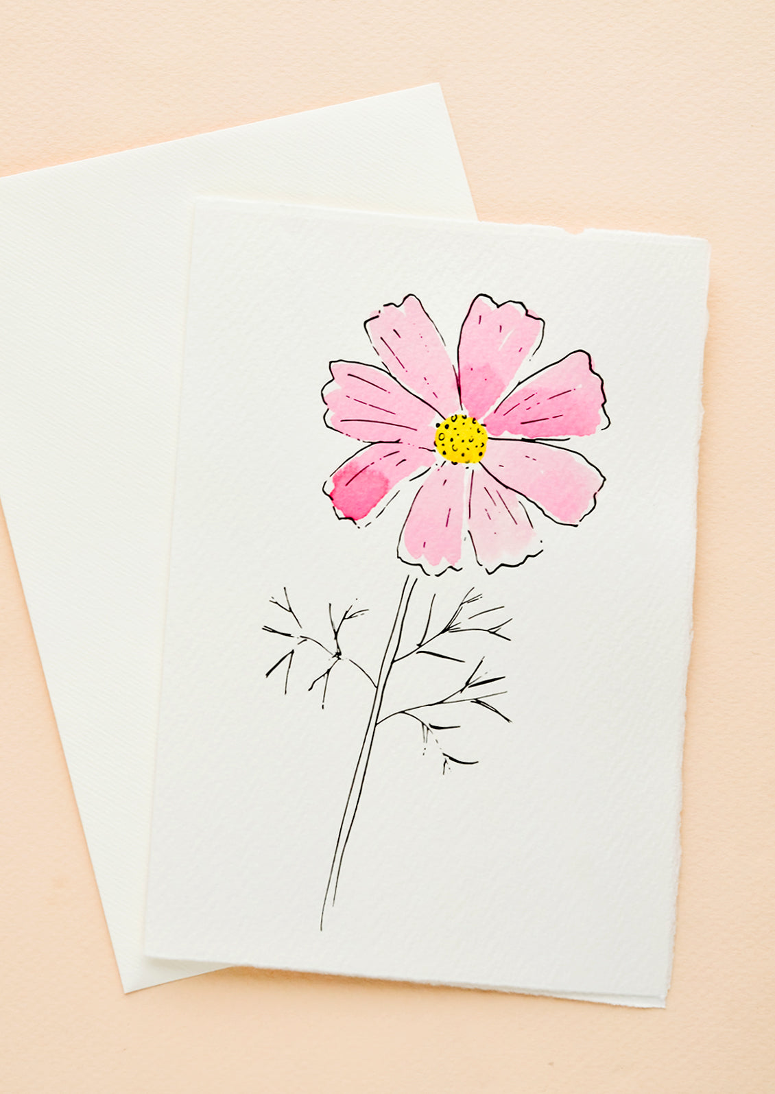 A white greeting card with a hand painted illustration of a pink cosmos flower.