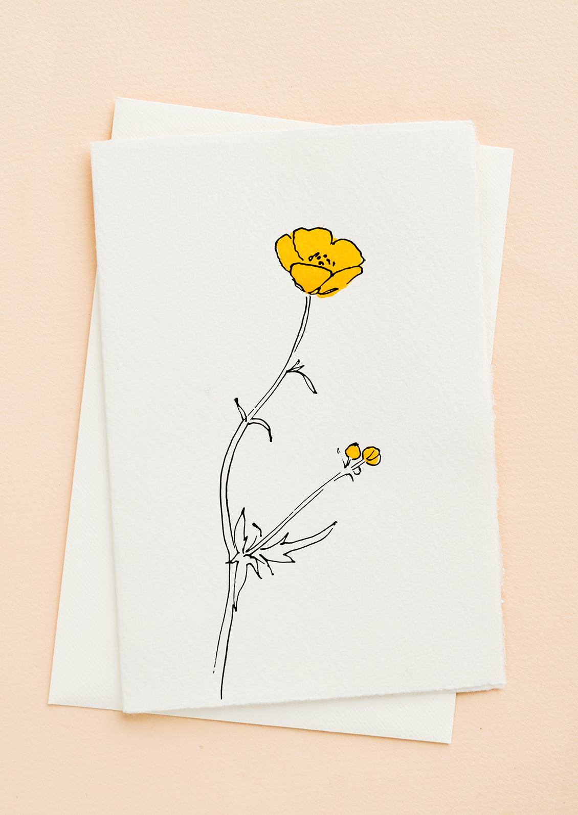 A white greeting card with a hand painted illustration of a buttercup flower.