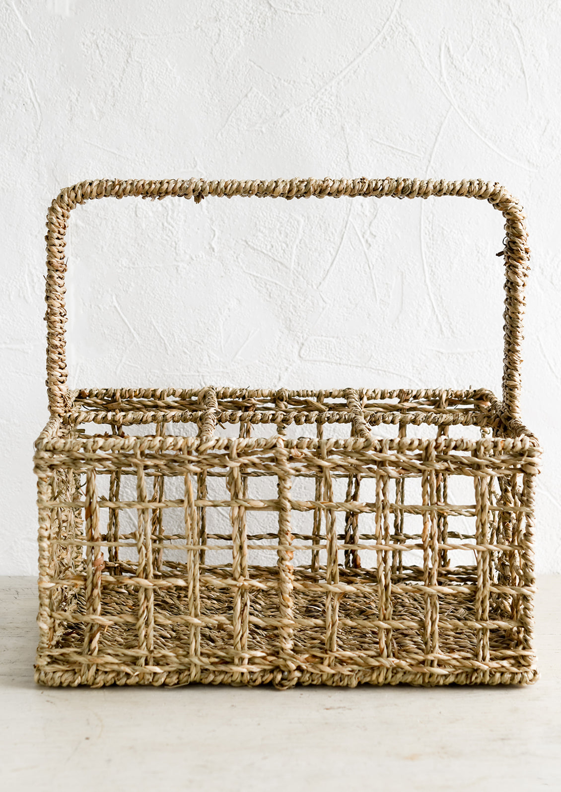 A rectangular seagrass carrying caddy with 6 compartments.