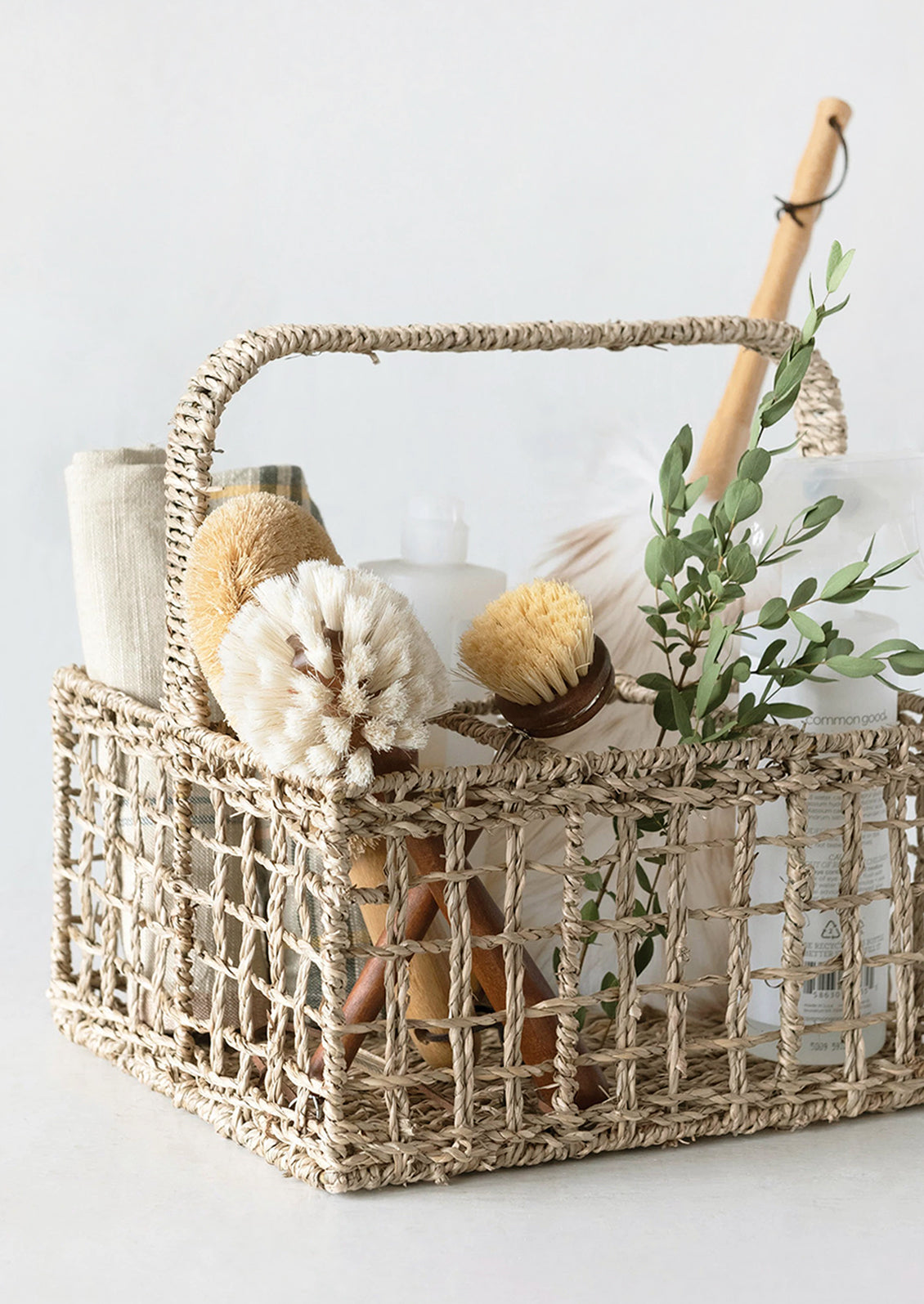 A seagrass caddy holding cleaning supplies.