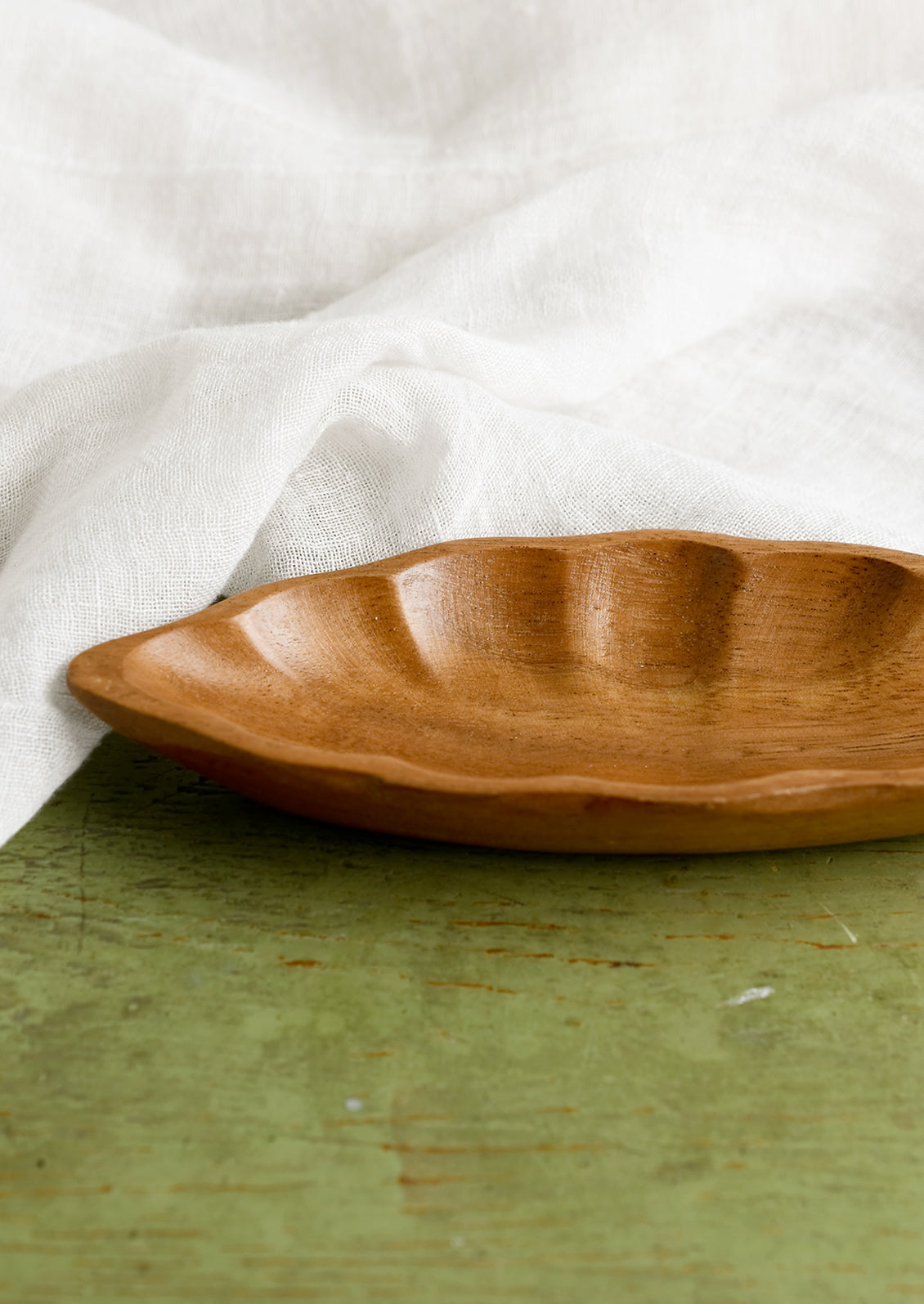 An elongated diamond or "seed pod" shaped wooden dish.