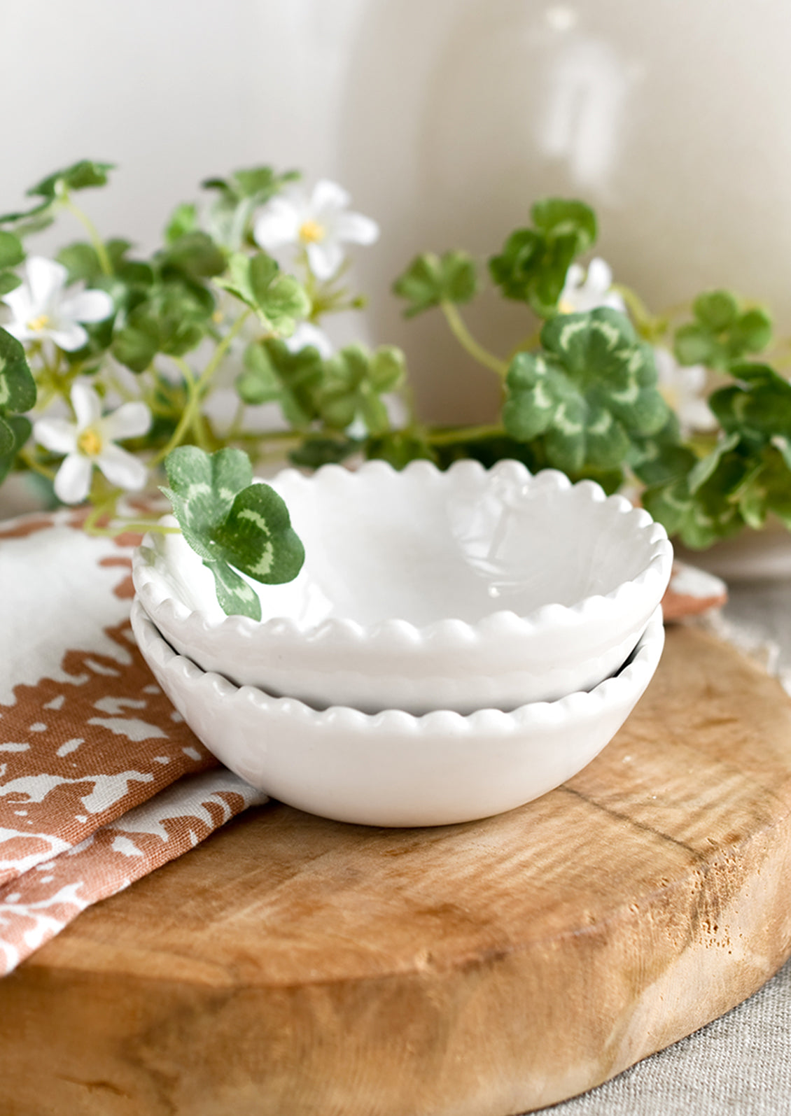 A small ceramic bowl with scalloped rim in white.
