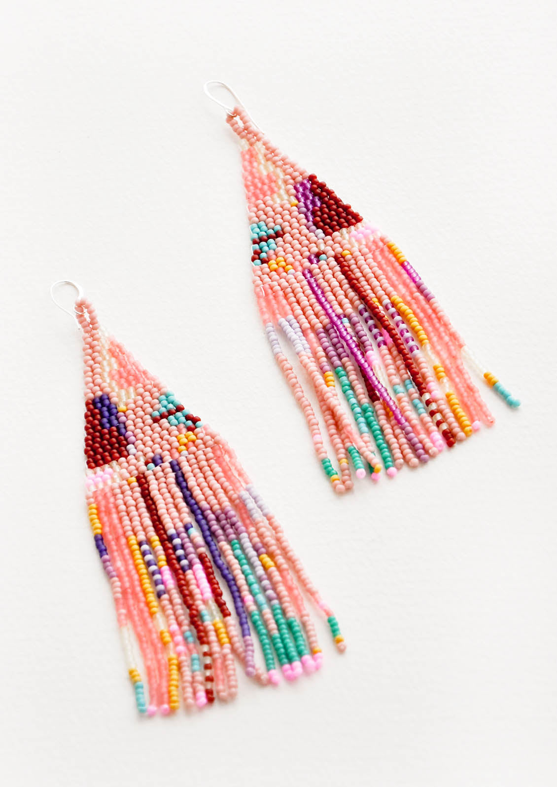 Pink fringe beaded earrings with irregular sections of blue, green, purple, maroon, yellow, and orange. 