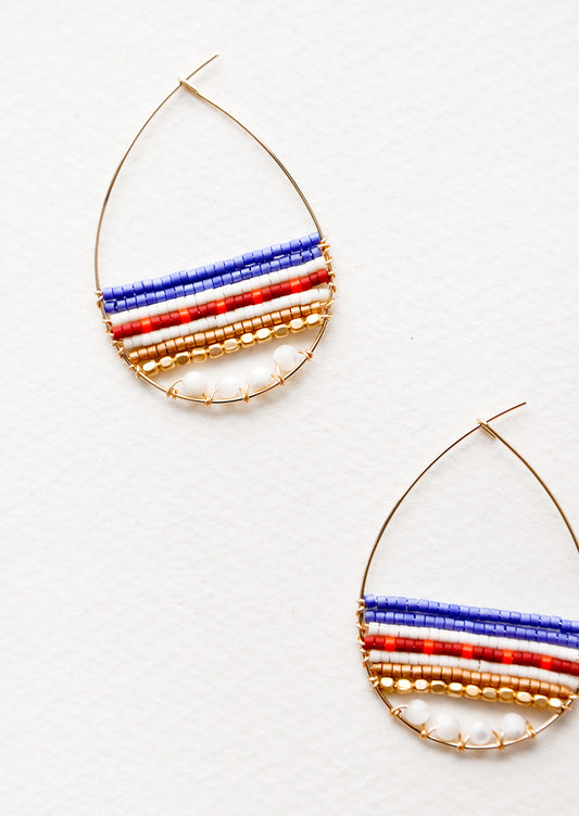 Teardrop shaped hoop earrings in yellow gold with multicolored beaded bars across. 