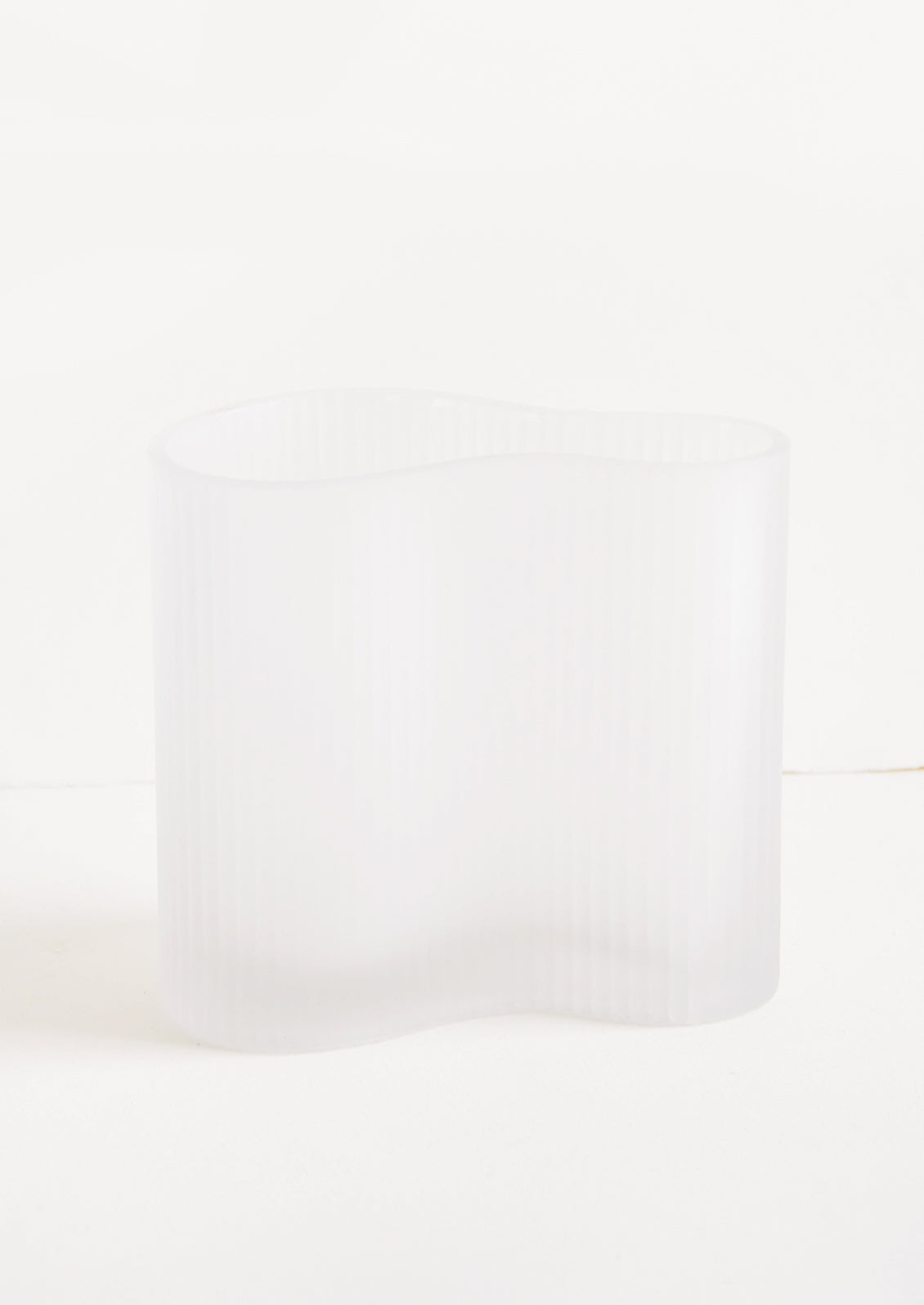 Frosted glass vase in curvy asymmetric shape with subtle ribbed texture