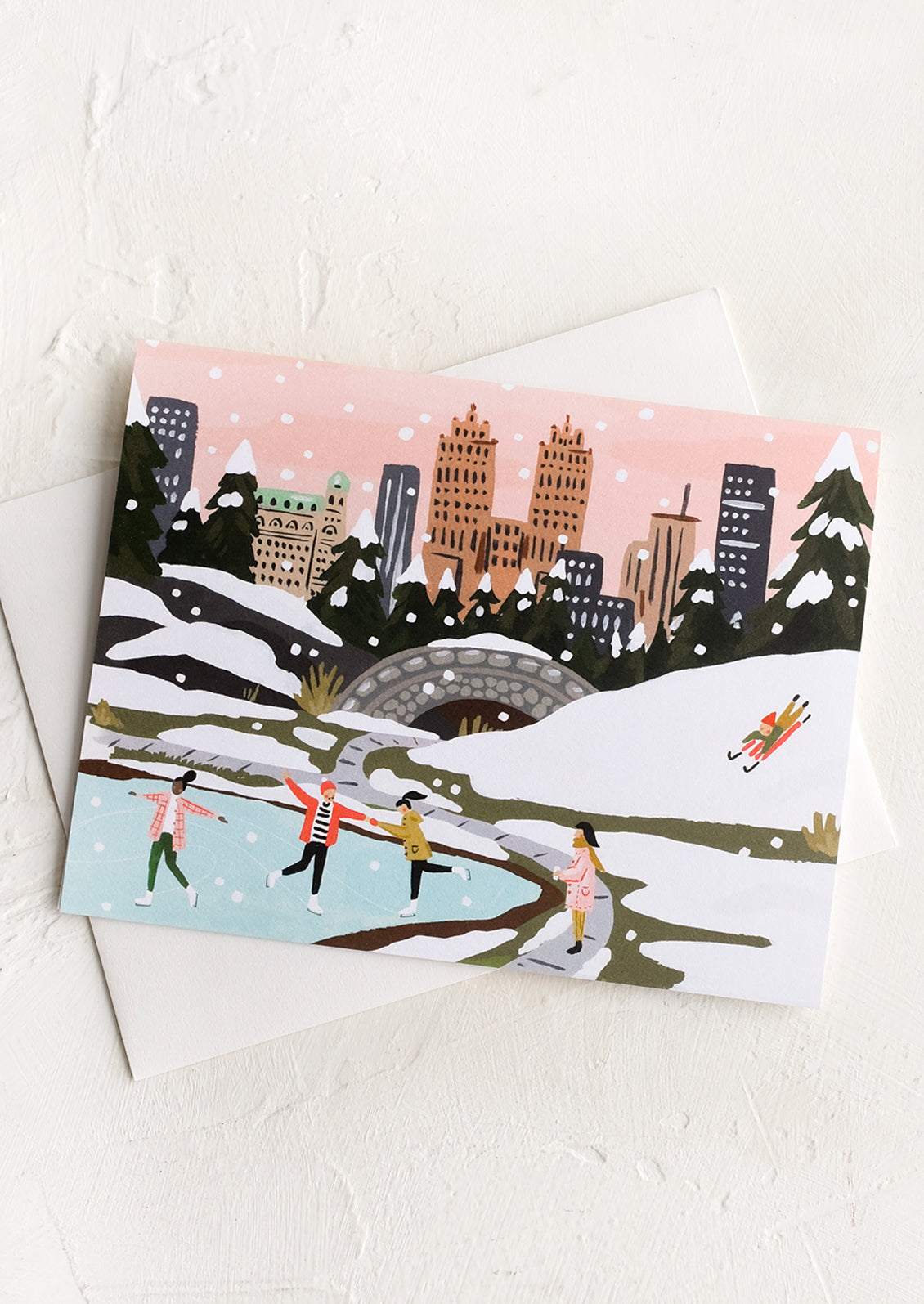 An illustrated greeting card depicting ice skaters in central park.