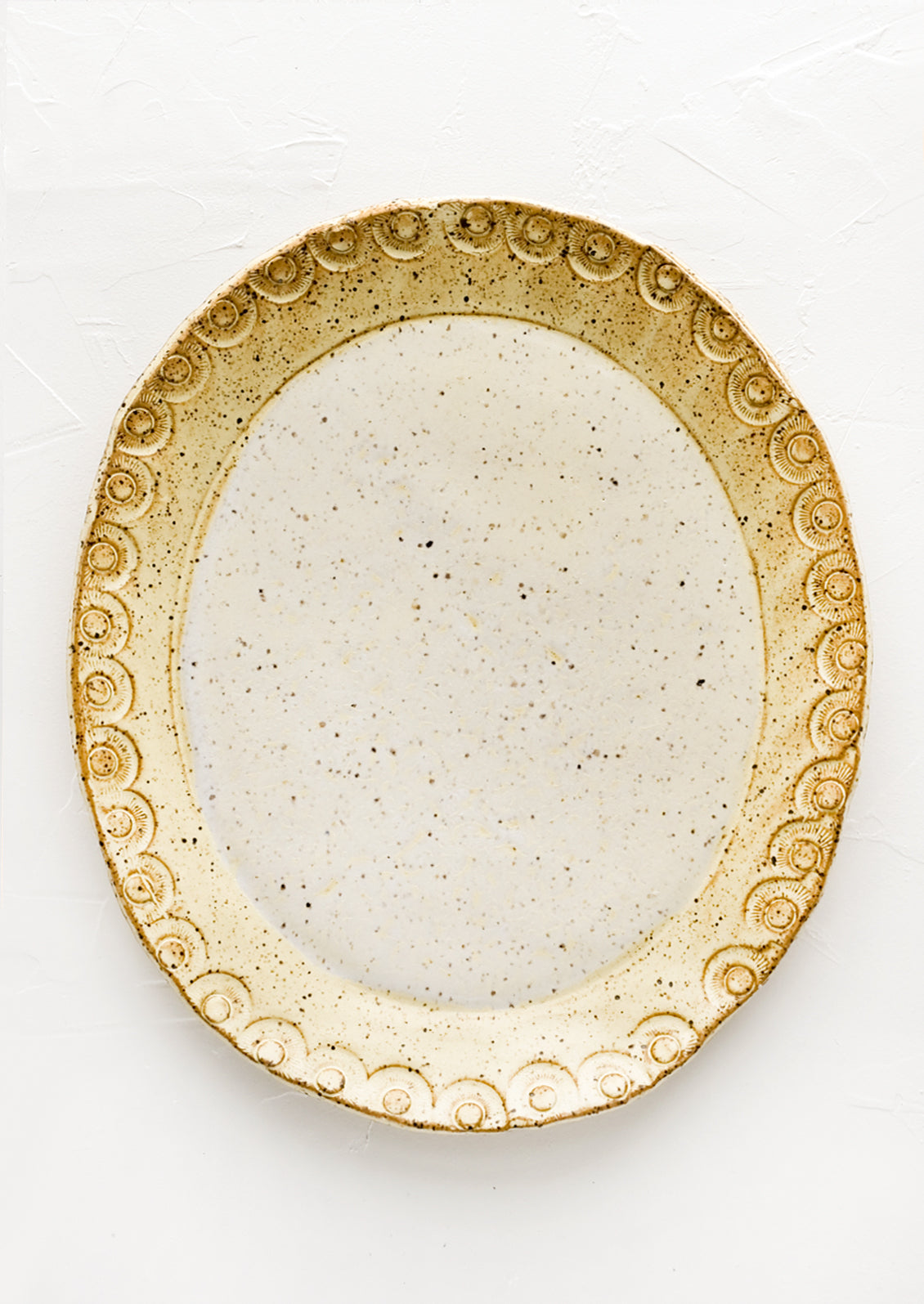 An oval shaped ceramic platter in pale yellow speckle.