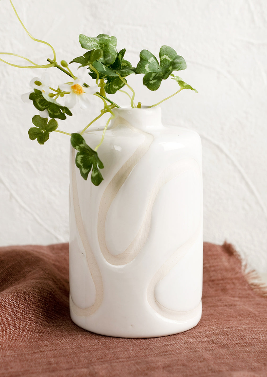 A glossy white ceramic vase with subtle cream squiggle design.