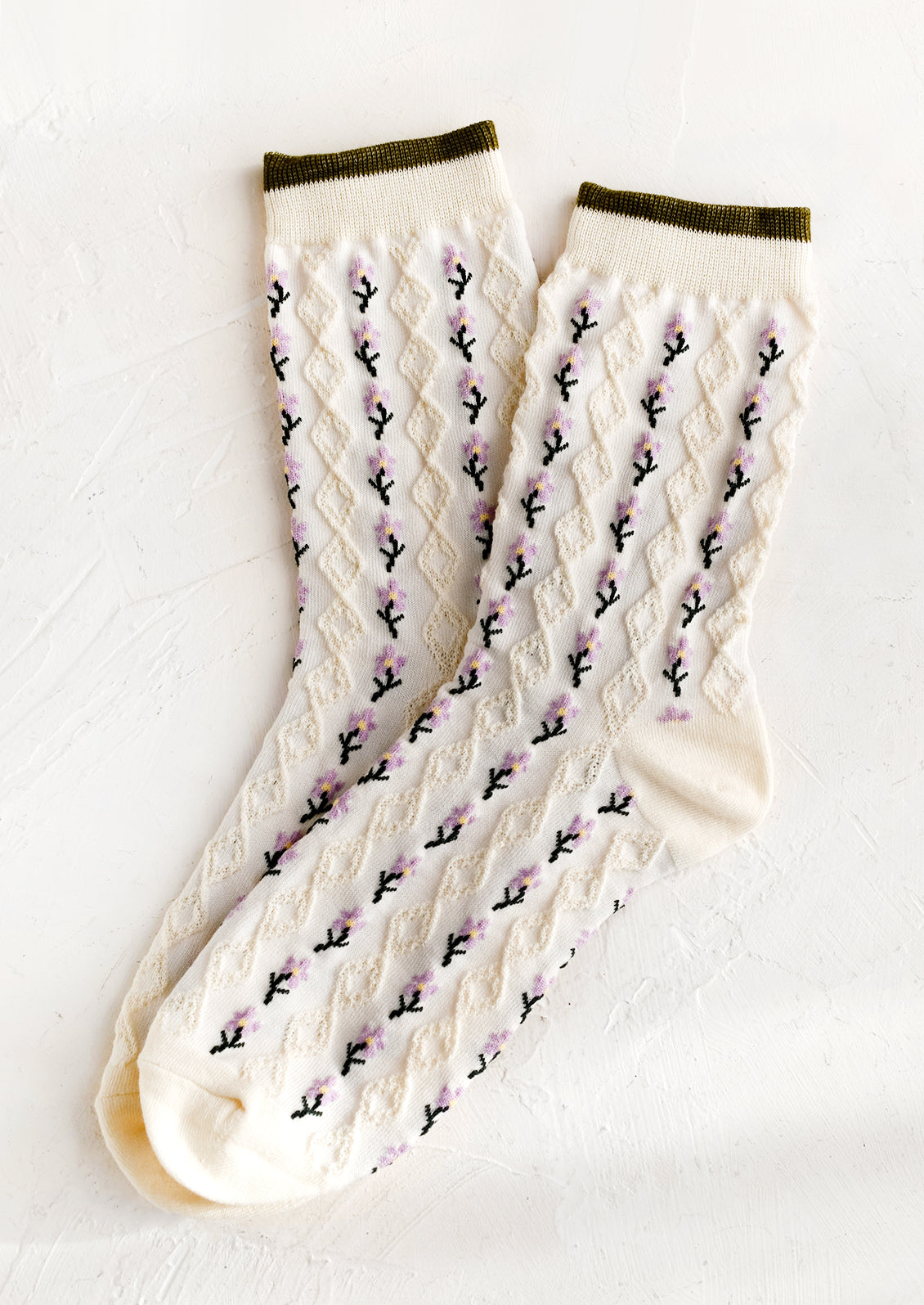 A pair of cream socks with purple flower vertical lines.