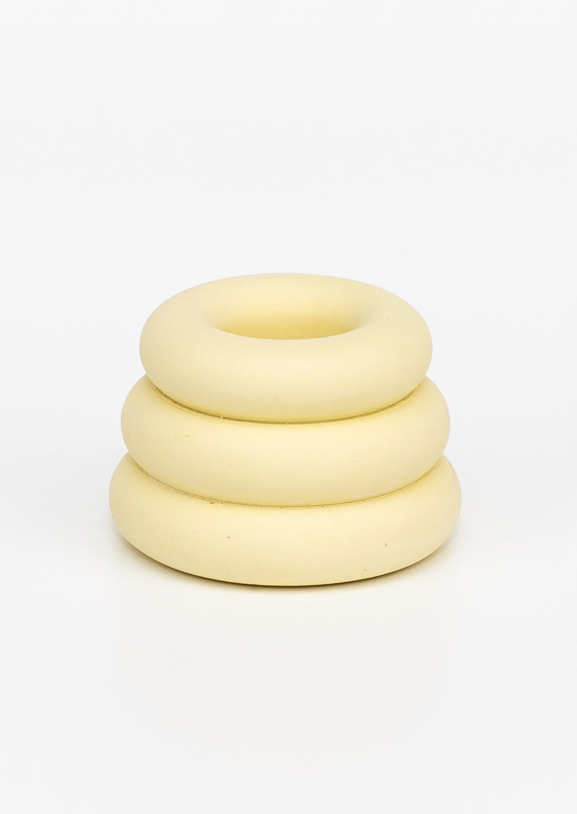 A taper candle holder with 3-layer stacked donut shape in pale yellow.