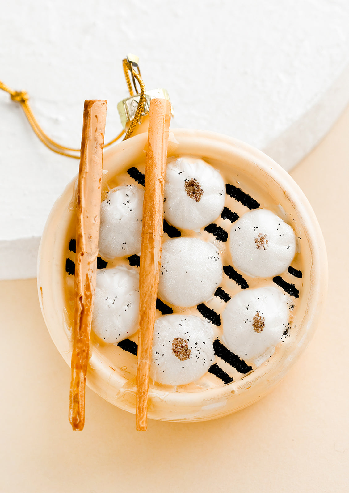 A holiday ornament of steamed dim sum dumplings in steam pot with chopsticks.