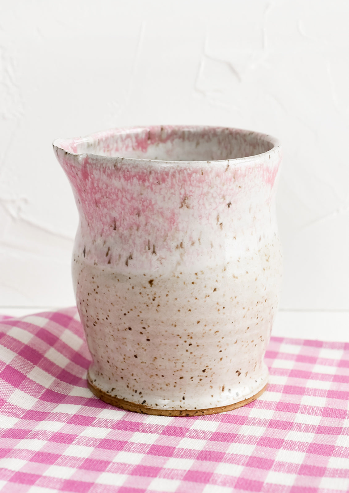 A small ceramic pitcher in mottled pink glaze.