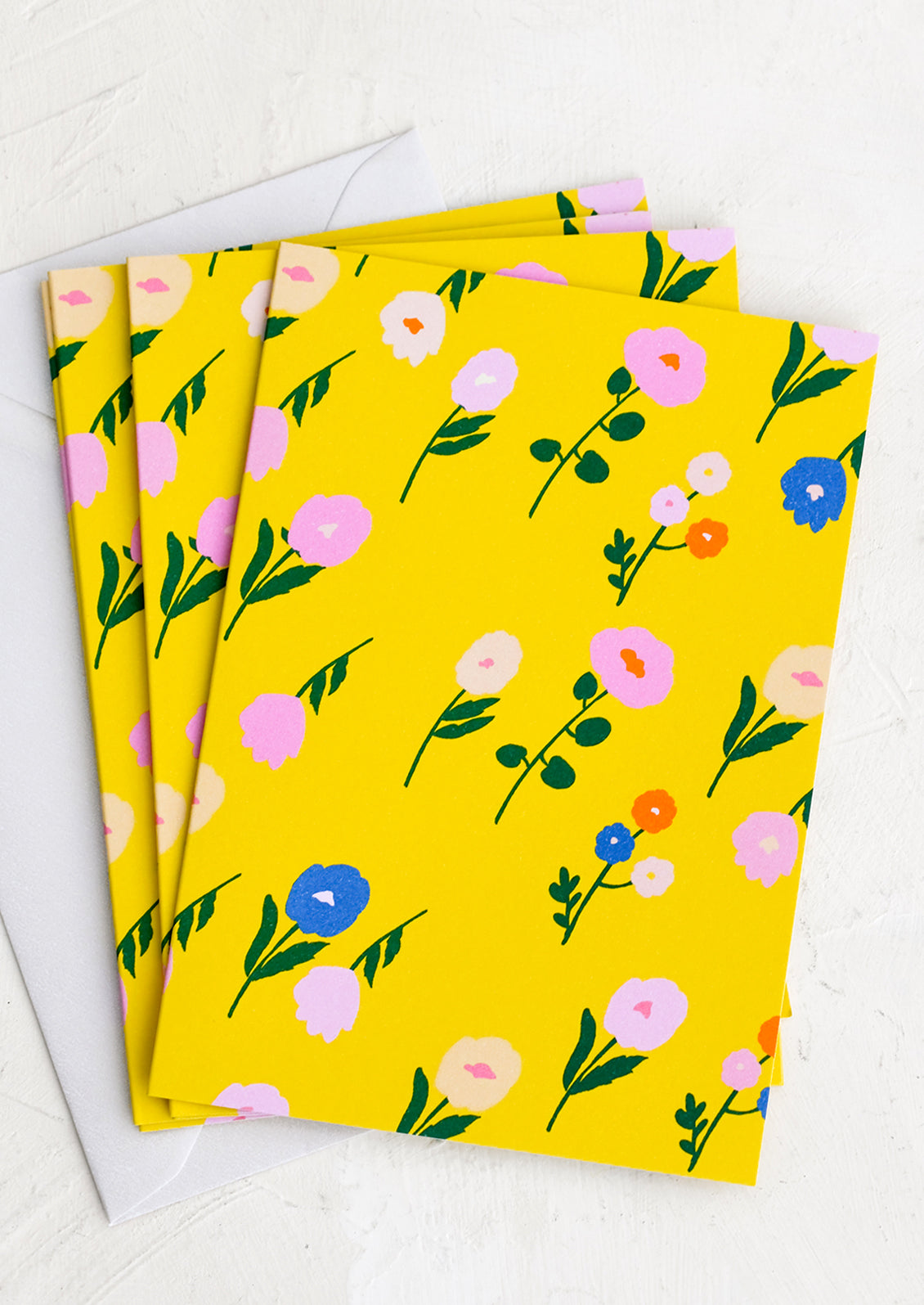 A set of yellow greeting cards with colorful floral print.