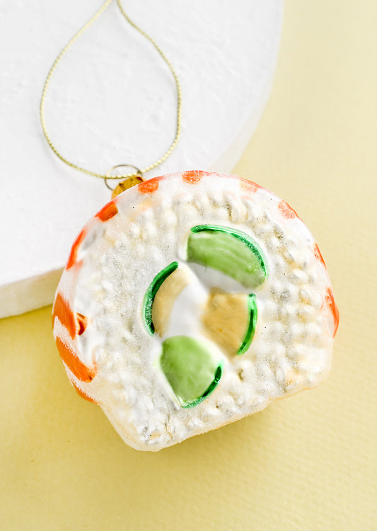 A decorative glass ornament in the shape of salmon avocado sushi roll.