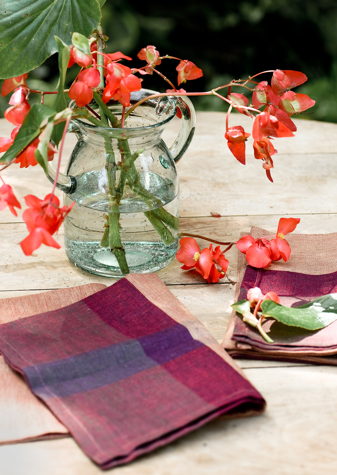 A pair of color overlay linen napkins on a table.