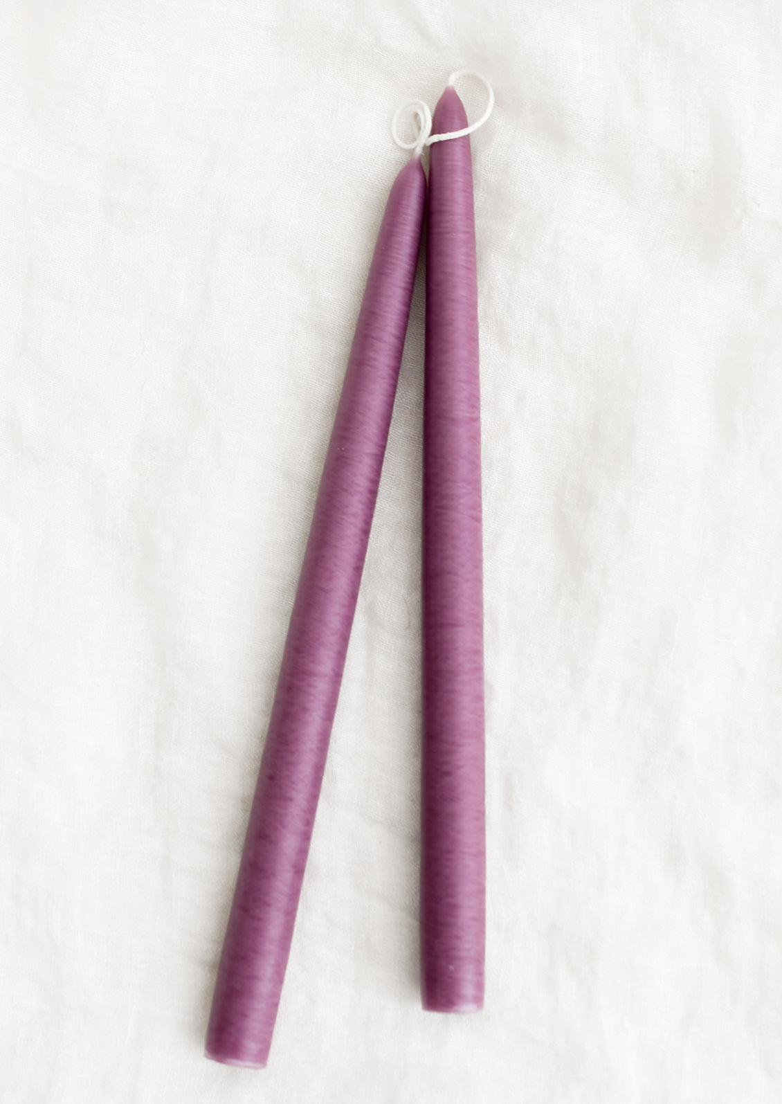 A pair of taper candles in elderberry purple.