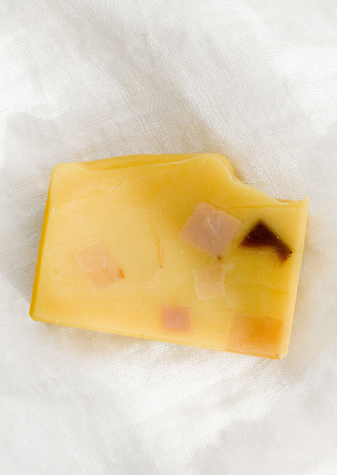 A yellow colored bar of soap with multicolor terrazzo pattern.