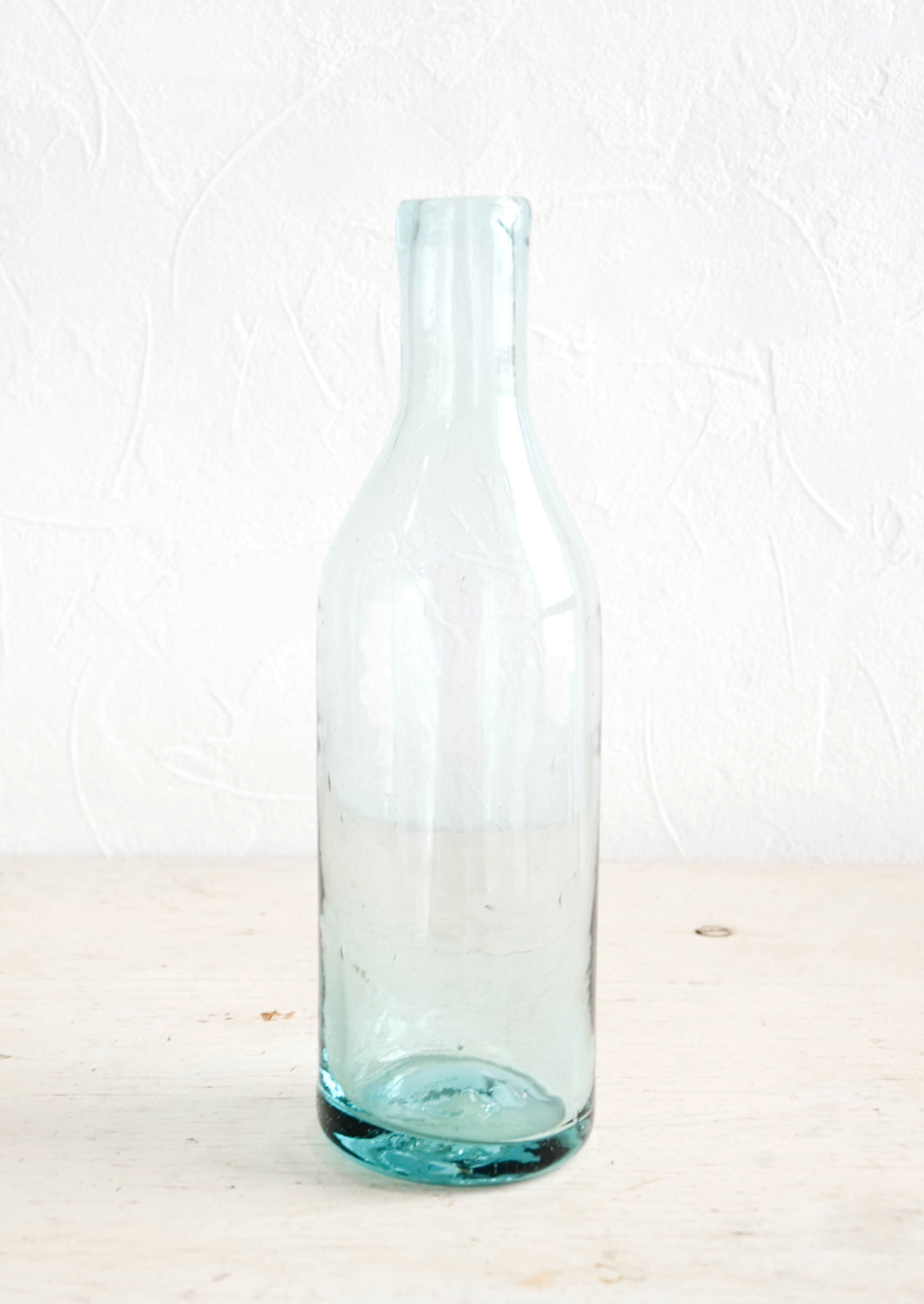 Wine-bottle shaped glass bottle in clear recycled glass