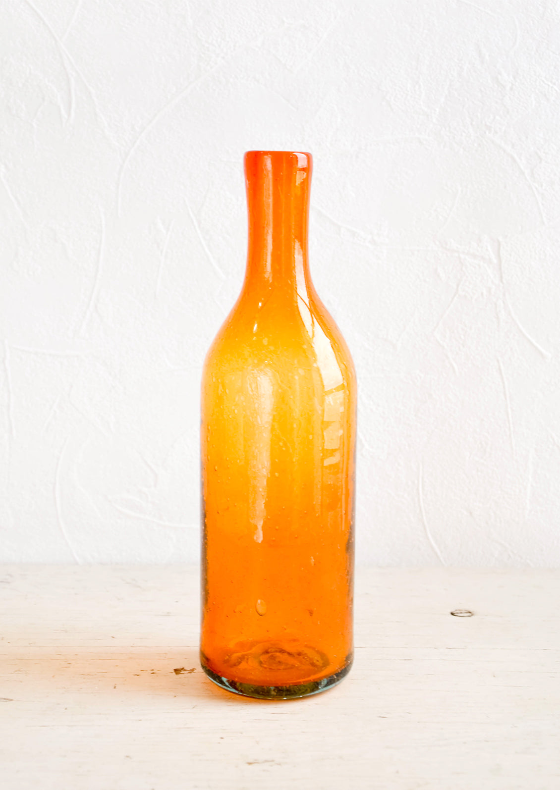 Wine-bottle shaped glass bottles in tinted orange hue