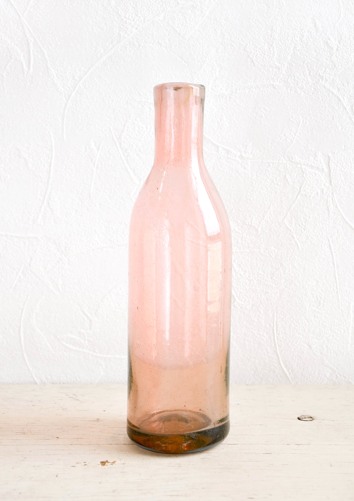 Wine-bottle shaped glass bottles in tinted pink hue