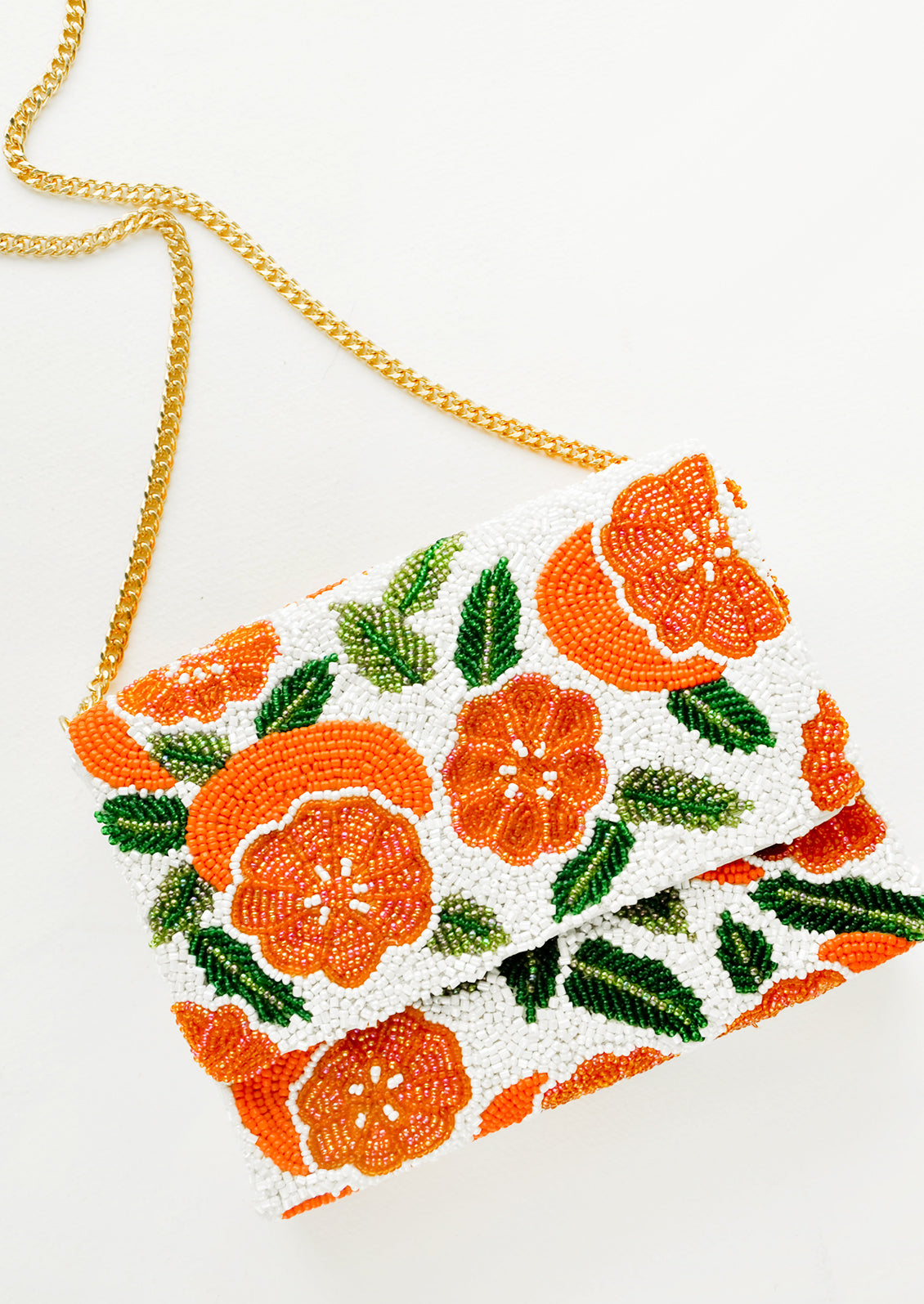 Beaded box-shaped clutch with orange citrus print and gold chain shoulder strap