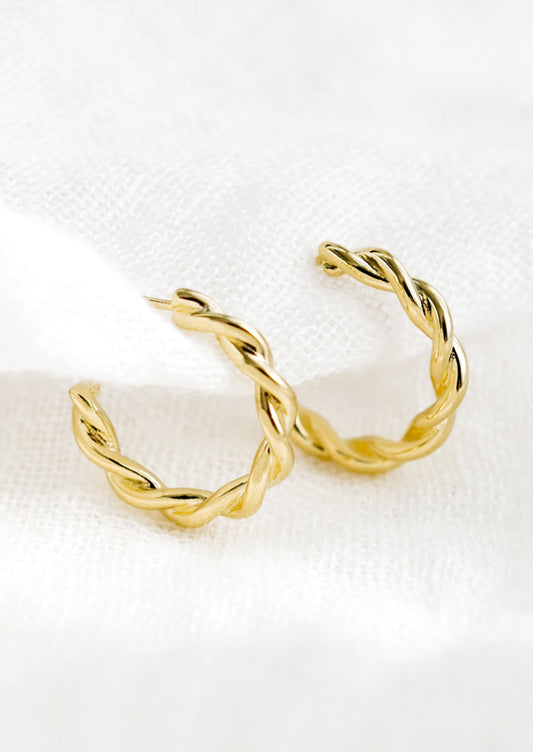 A pair of gold twist hoop earrings.