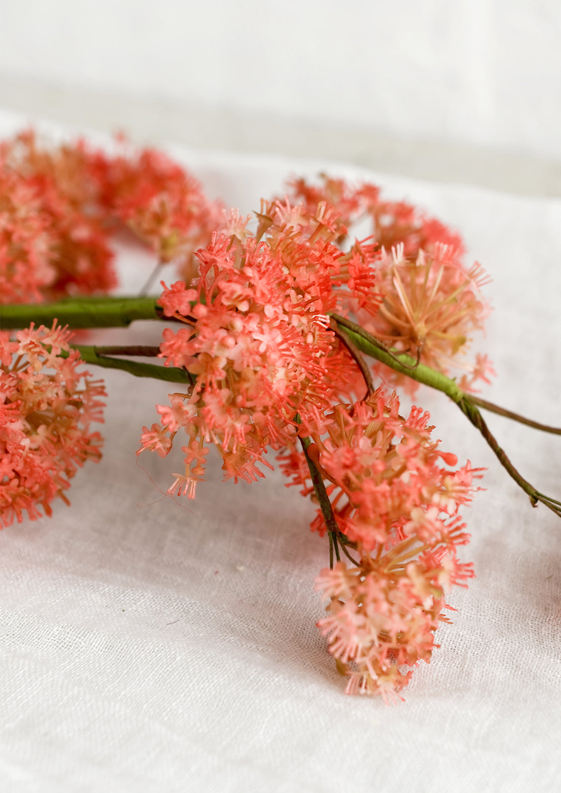 A faux stem of coral valerian flower.