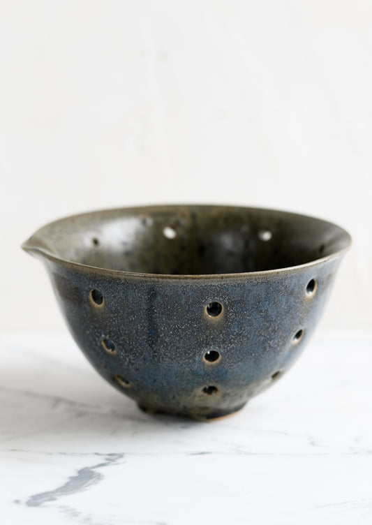 A petrol ceramic stoneware colander.