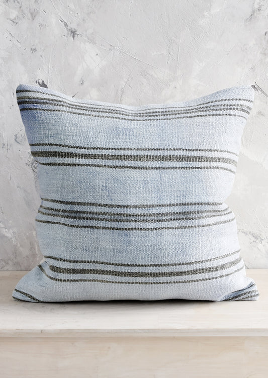 A square throw pillow in vintage light blue hemp with charcoal stripes.