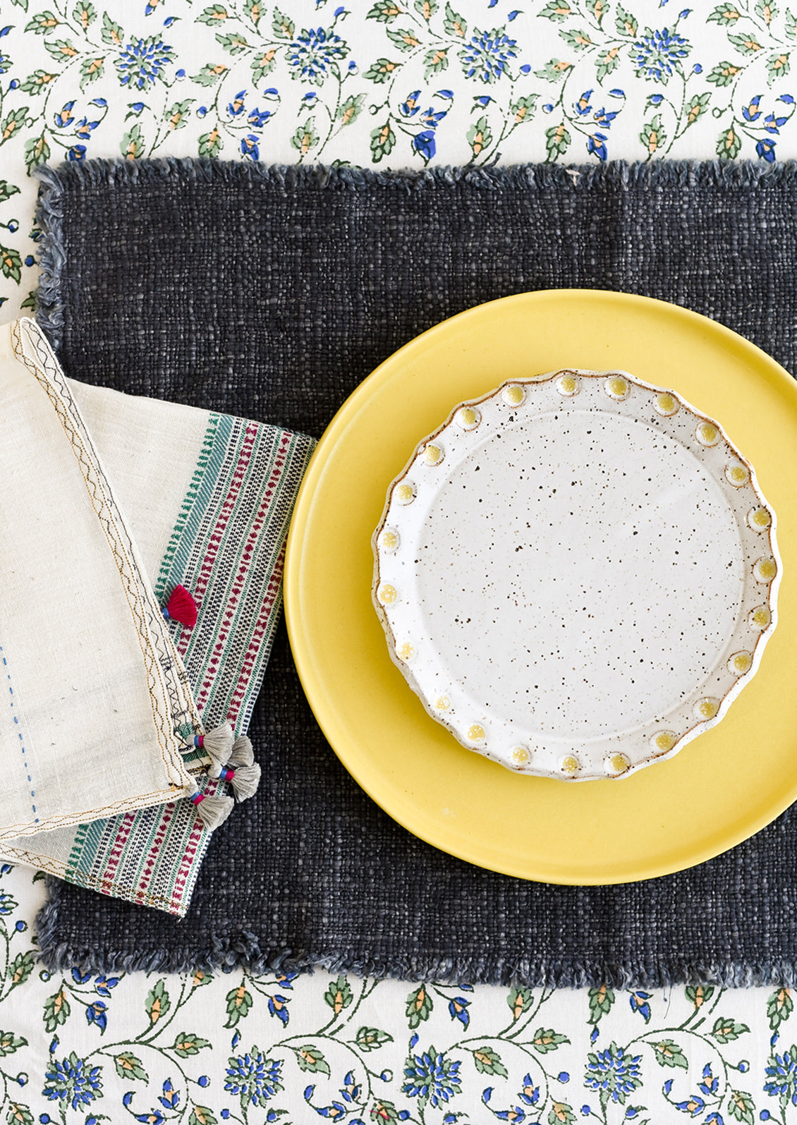 A whimsical table setting with colorful textiles and ceramics.