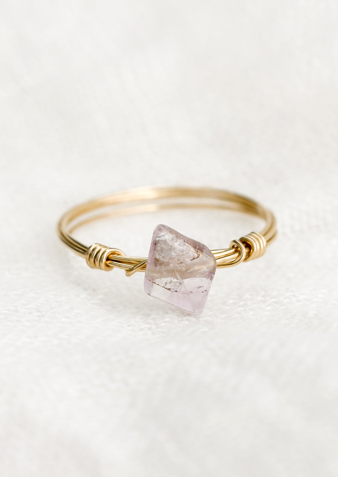 A gold wire wrap ring with diamond-shaped amethyst gemstone.