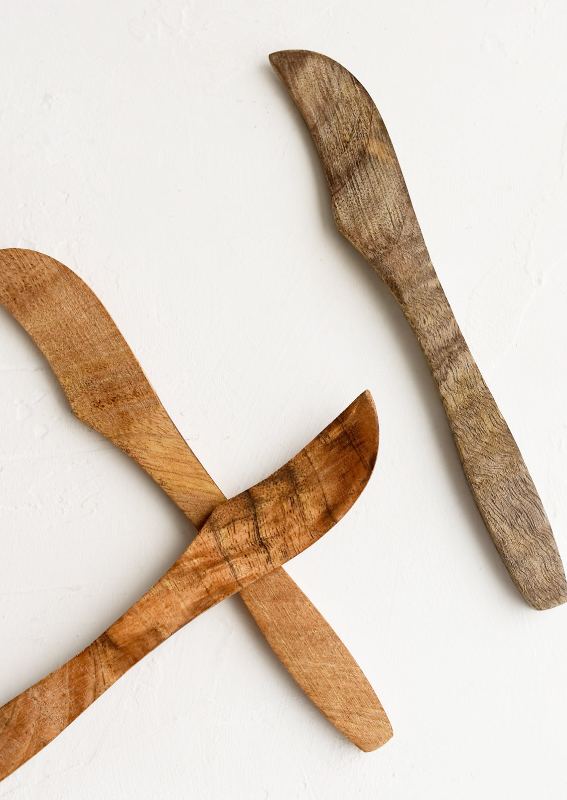 Wooden butter knives showing slightly varied wood colors.