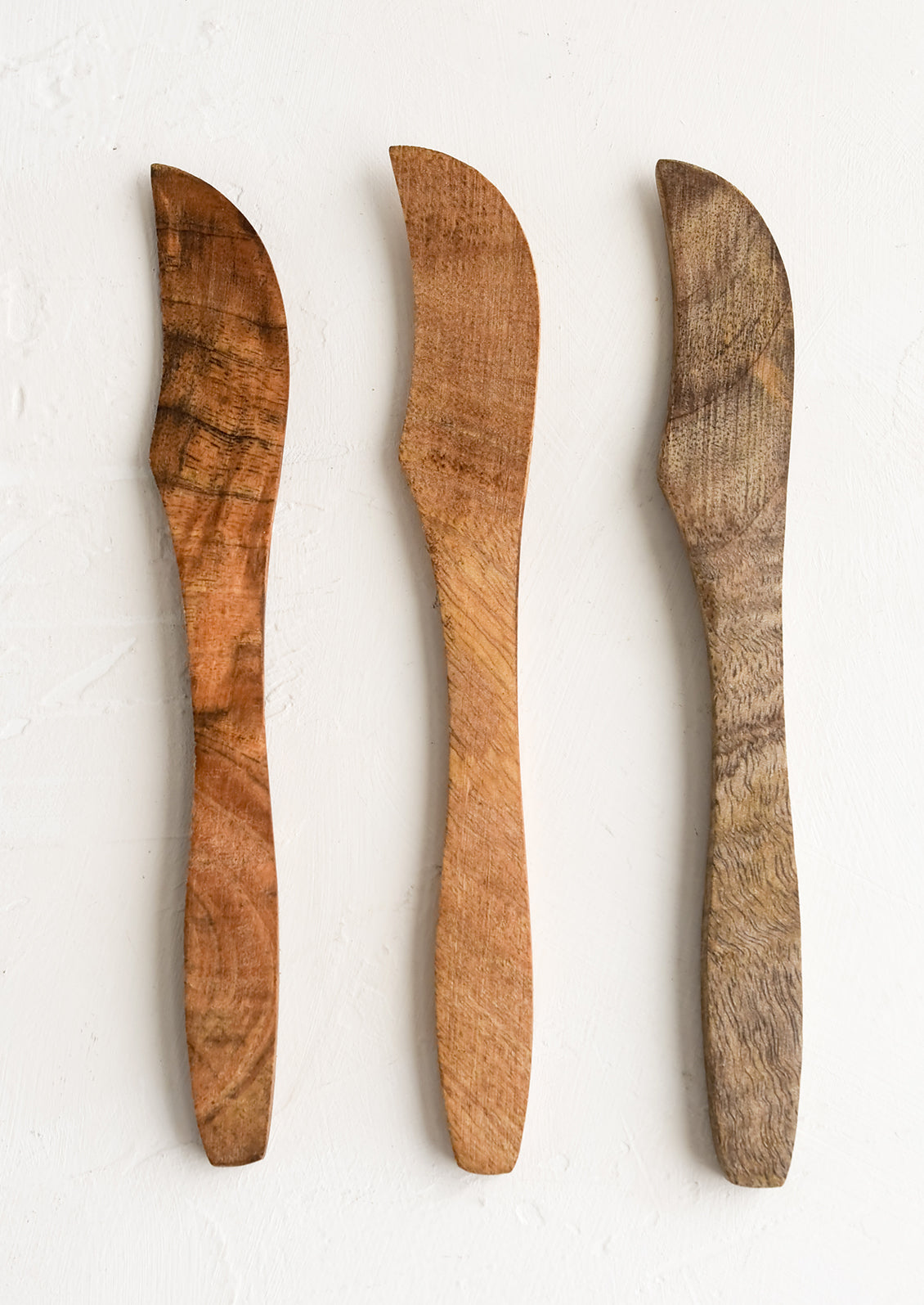 Wooden butter knives showing slightly varied wood colors.